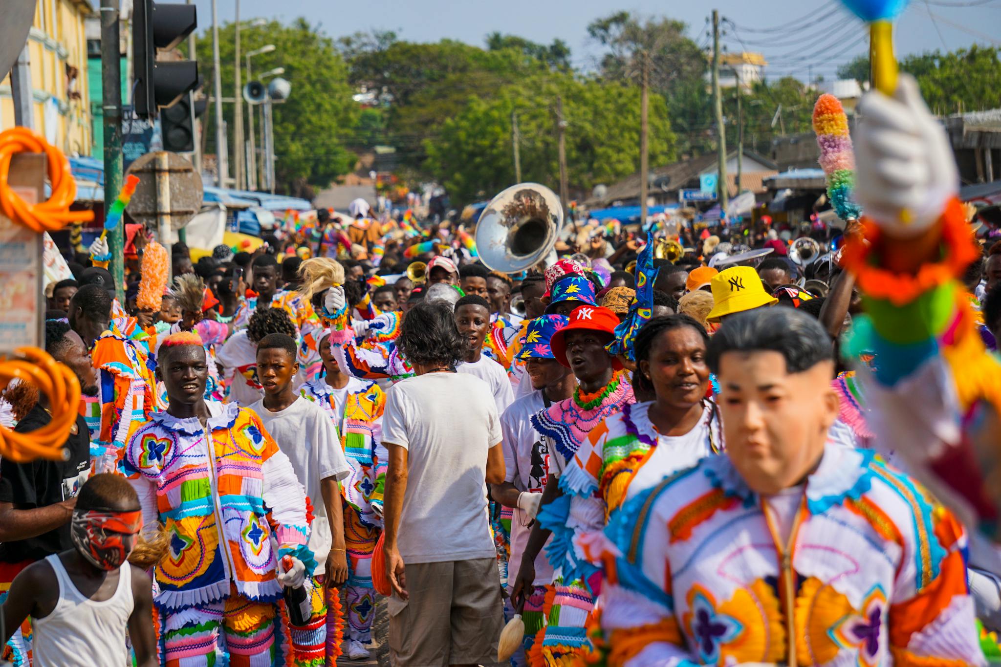A lively street parade featuring people in colorful costumes, celebrating cultural festivities.